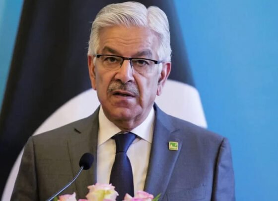 Khwaja Asif, a prominent Pakistani politician, speaking passionately at a podium during a political event.
